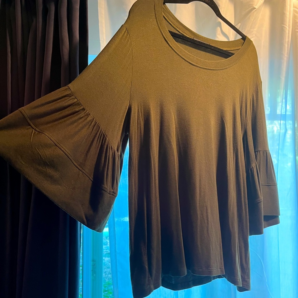 Olive green knit top with ruffle sleeve trim.